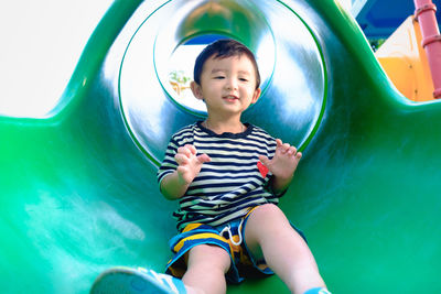 Smiling boy playing on slide 