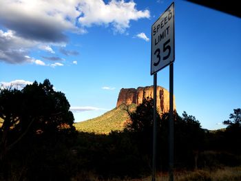 Low angle view of road sign against sky