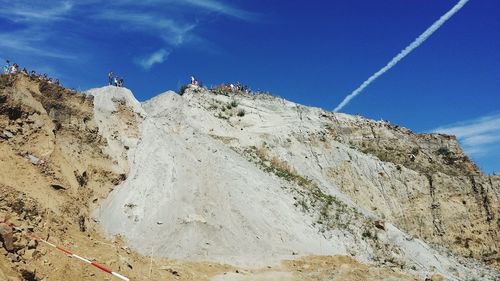 Low angle view of rocks on mountain against sky