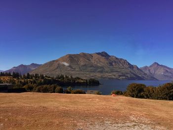 Scenic view of landscape and mountains against clear blue sky