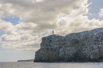 Lighthouse by sea against sky