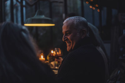 Happy mature man during dinner party at night