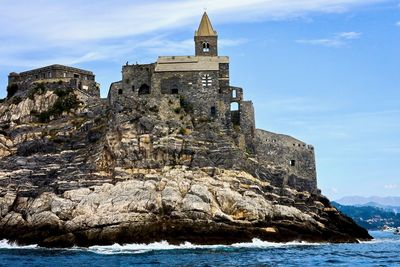 Historic building by rock against sky