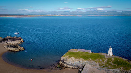 High angle view of sea and lighthouse against sky