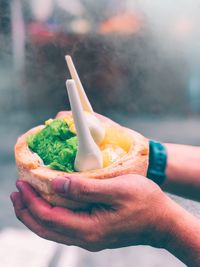 Cropped hands holding food outdoors