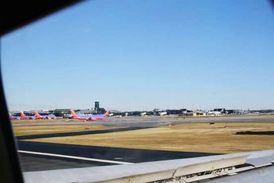 Airplane on airport runway against clear blue sky