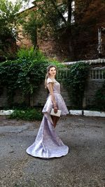 Young woman standing against tree