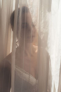 Portrait of woman looking through window