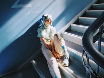 Thoughtful woman looking away while sitting on steps