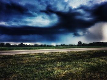 Scenic view of field against cloudy sky