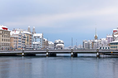 Bridge over river against buildings in city