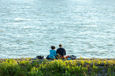 Rear view of friends sitting in lake