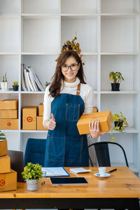 Portrait of smiling young woman standing in kitchen