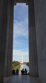 Rear view of people sitting at lincoln memorial against washington monument