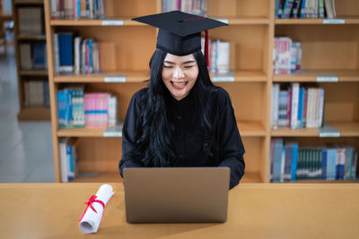 Young student using laptop while sitting at library