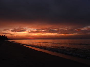 Scenic view of sea against dramatic sky during sunset