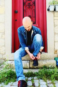 Full length of young man sitting outdoors