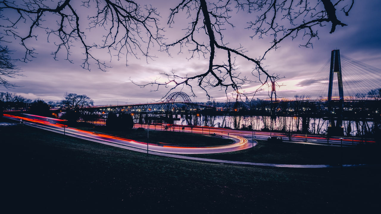 LIGHT TRAILS ON ROAD AGAINST SKY