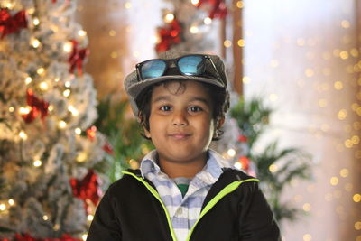 Portrait of smiling boy against christmas tree
