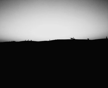 Silhouette person on landscape against clear sky