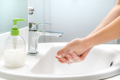 Cropped image of person with ice cream in bathroom