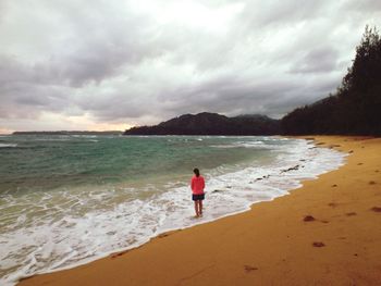 Scenic view of beach against cloudy sky