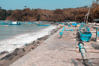 Boats moored on beach against sky