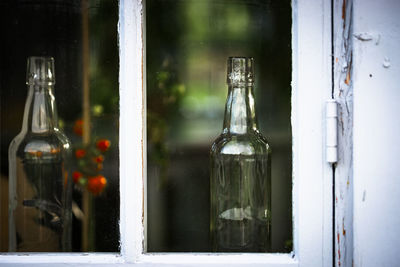 Close-up of wine bottles on window