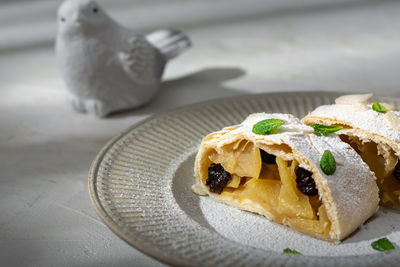 Close up of apple austrian strudel with cinnamon and mint on a plate