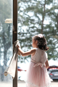 Rear view of woman looking through window