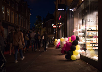 People walking on illuminated street at night