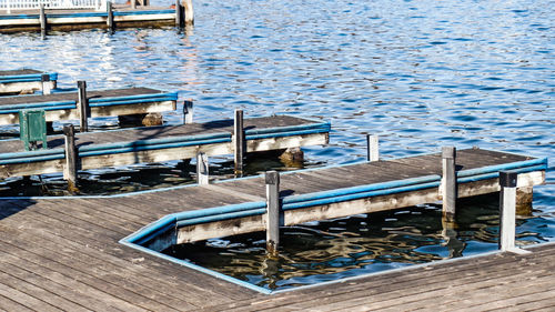 High angle view of empty chairs on pier at lake