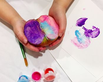 Close-up of hand holding painted apple