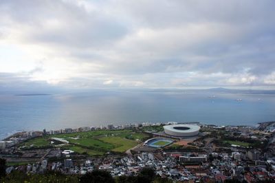 High angle view of townscape by sea against sky