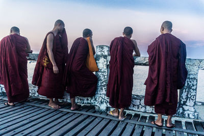 Rear view of people standing against sky