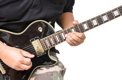 Midsection of man playing guitar against white background