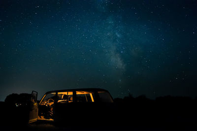 Silhouette car against sky at night