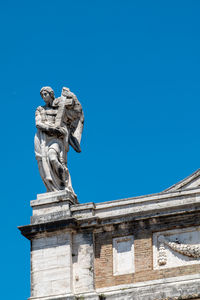 Low angle view of statue against blue sky