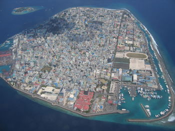 High angle view of cityscape by sea against sky