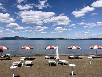 Scenic view of beach with classic umbrellas against sky