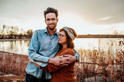Happy couple hugging near a lake in denver co on a autumn evening