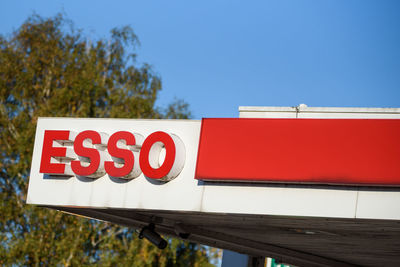 Low angle view of sign against blue sky