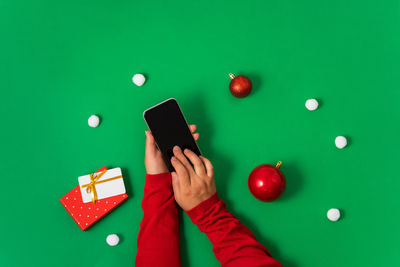 Cropped hand of woman using mobile phone on table