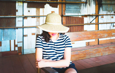 Midsection of woman sitting against railing