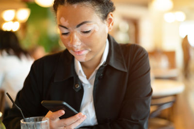 Woman using mobile phone in restaurant