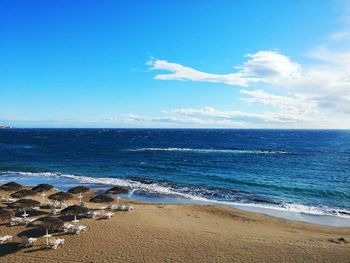 Scenic view of beach against cloudy sky