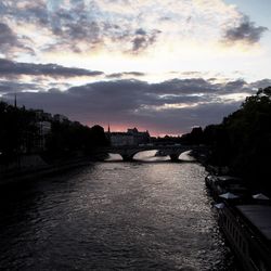 Bridge over river against cloudy sky