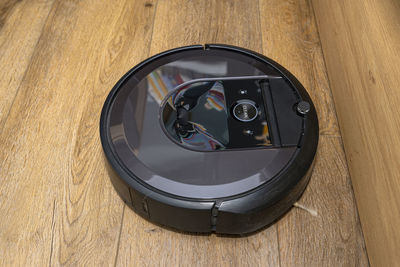 A modern robotic vacuum cleaner running on vinyl panels, an autonomous cleaning robot.