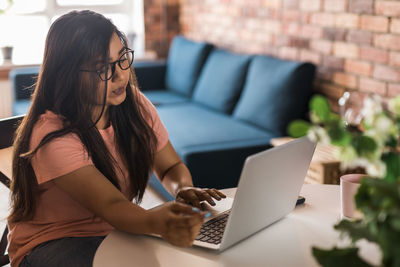 Young woman using laptop at home