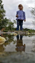 Full length of girl standing by puddle